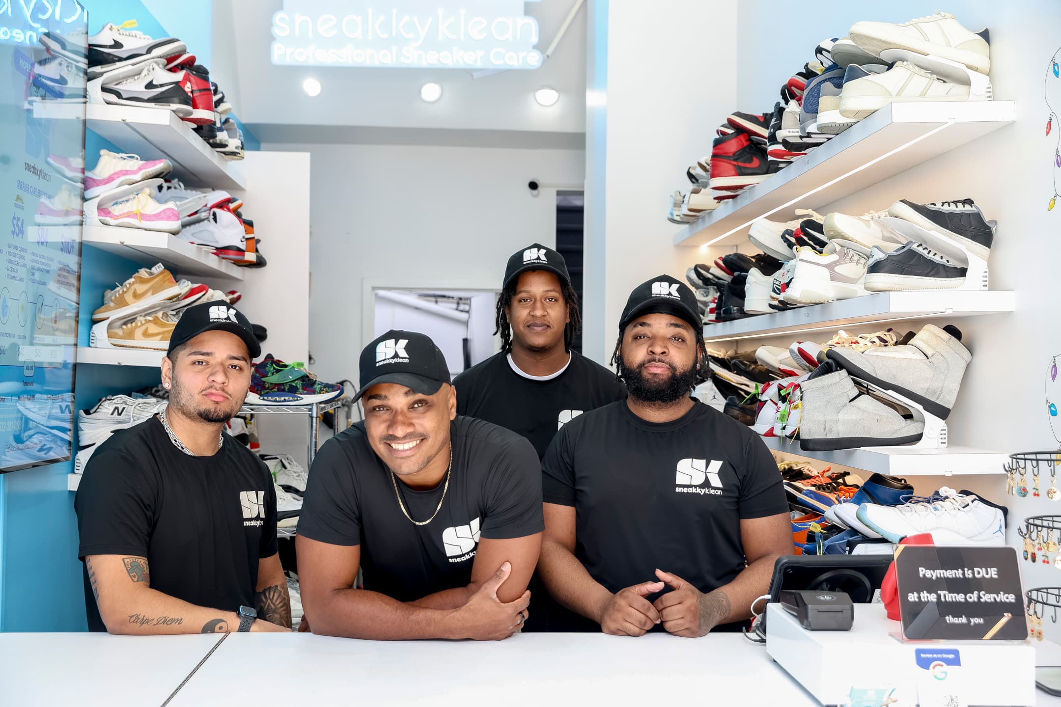 The Sneakky Klean team behind the front counter, surrounded by curated sneaker shelves.